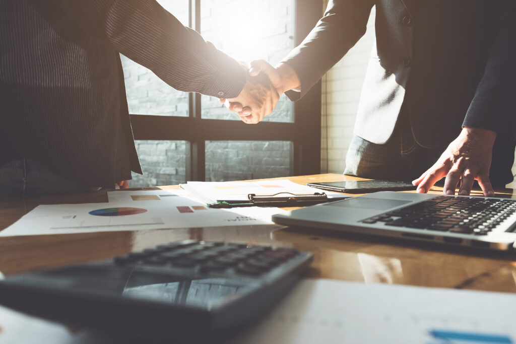 Business,Partnership,Meeting,Concept.,Image,Businessmans,Handshake.,Successful,Businessmen,Handshaking Adult site broker shaking client's hand above messy desk